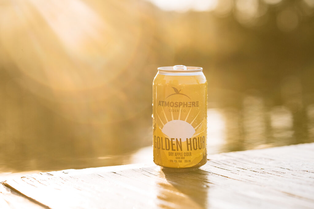 A can of Golden Hour on a lakeside dock in evening light
